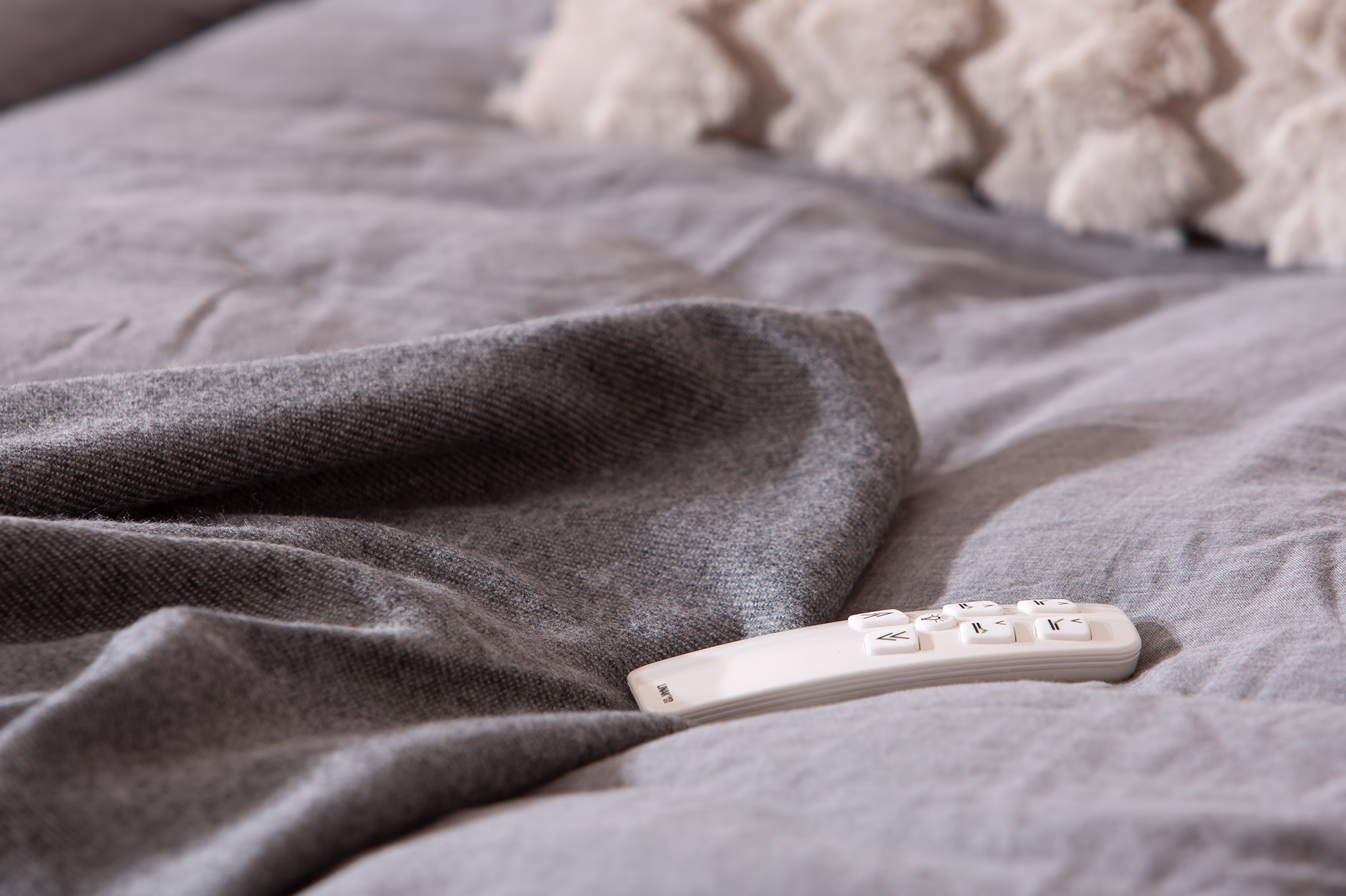 Moon Silver motorized bed in Primo 84 light gray fabric, showing the raised adjustable headrest