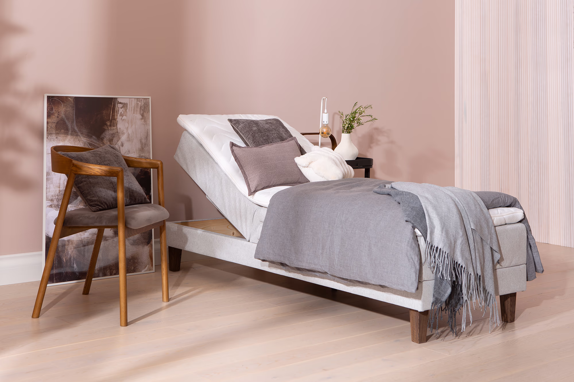 Motorized bed control panel resting on Moon Silver bed beside light gray mattress