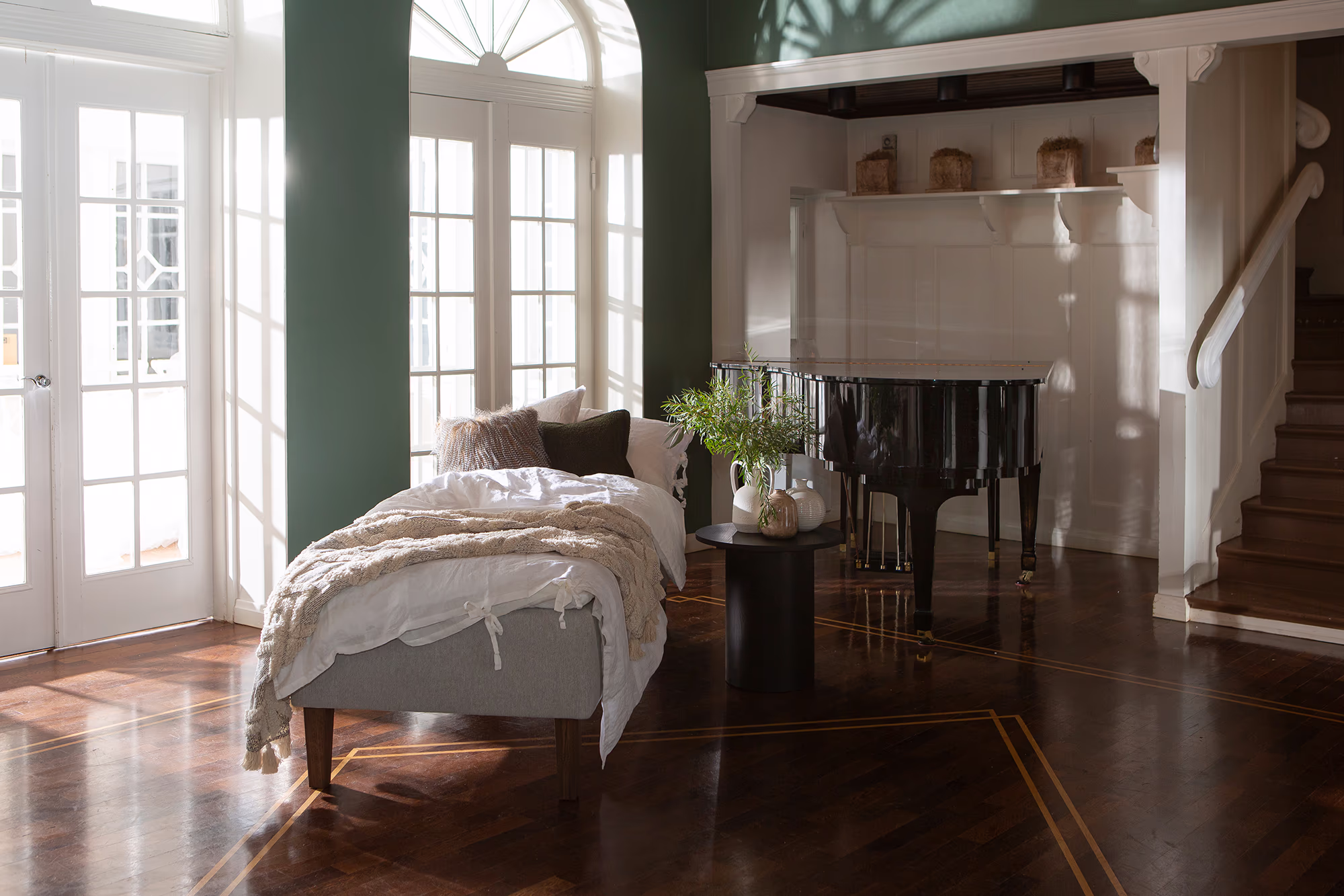 Side view of the Moon Bronze divan bed showing the durable wooden frame and the elegant Primo 84 light grey upholstery with conical smoked ash legs.
