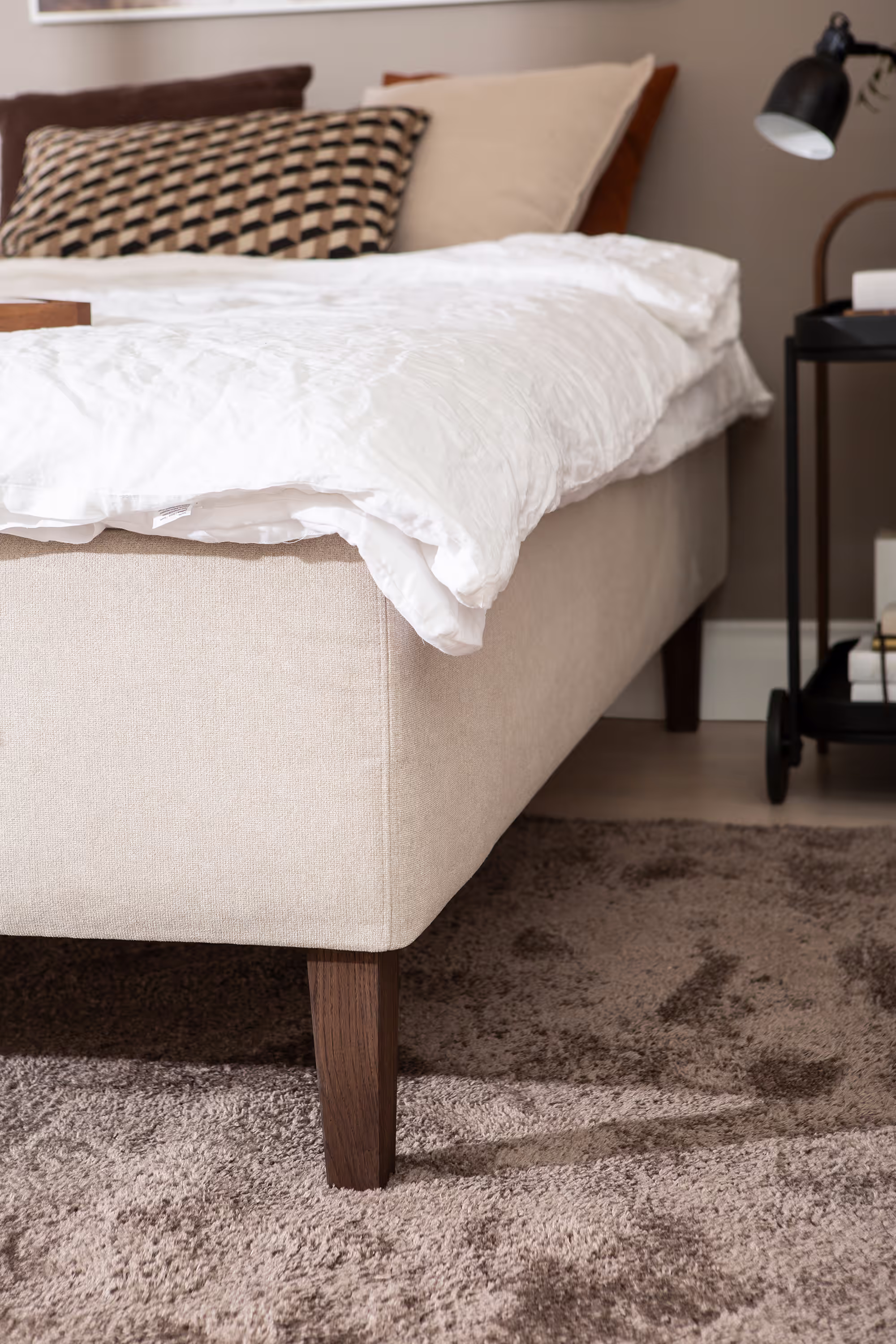Close-up view of the beige upholstery texture of the Moon Gold divan bed highlighting the quality fabric and neat stitching.