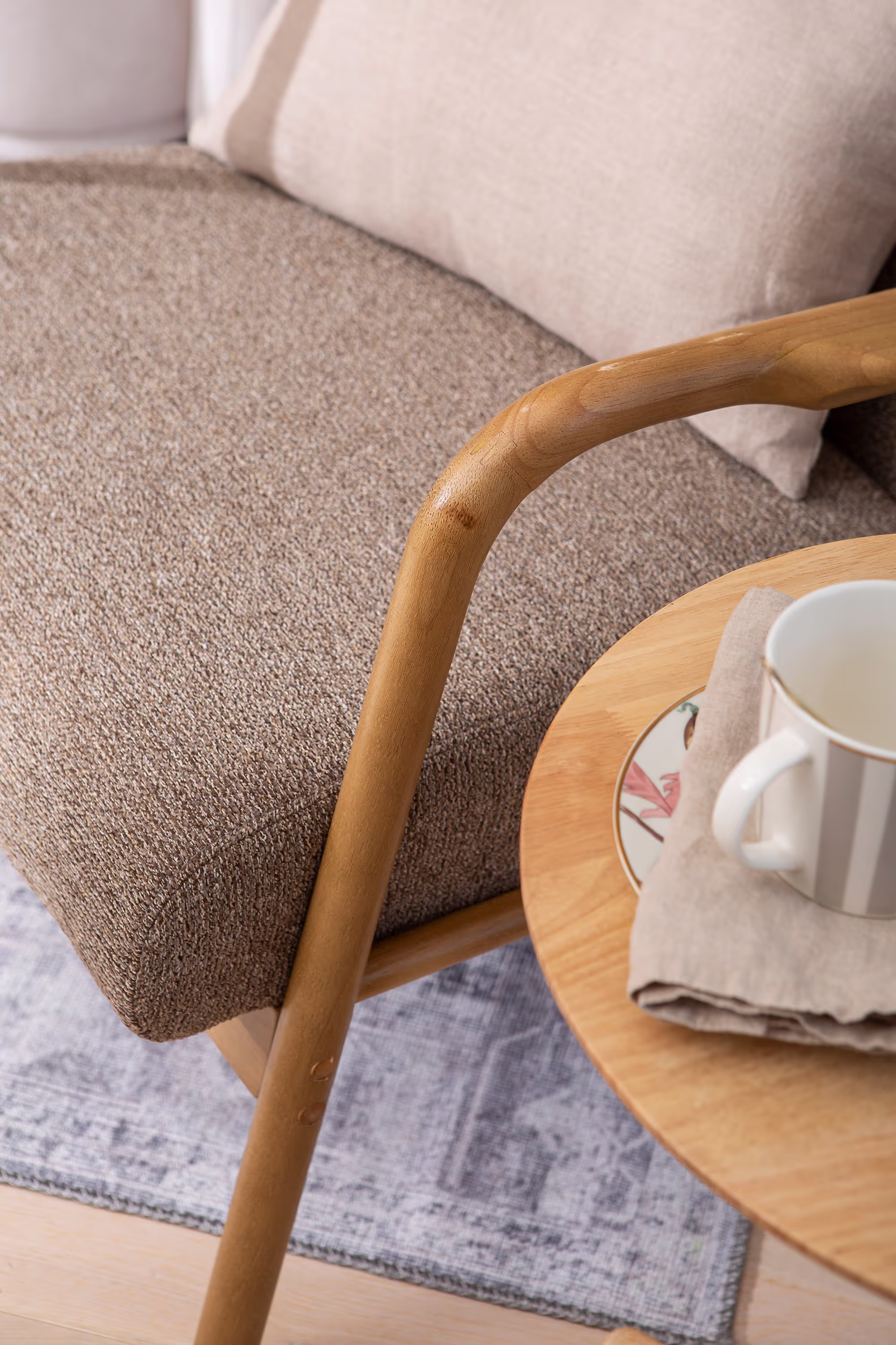 Side view of Dove armchair highlighting clean lines of frame and soft brown fabric