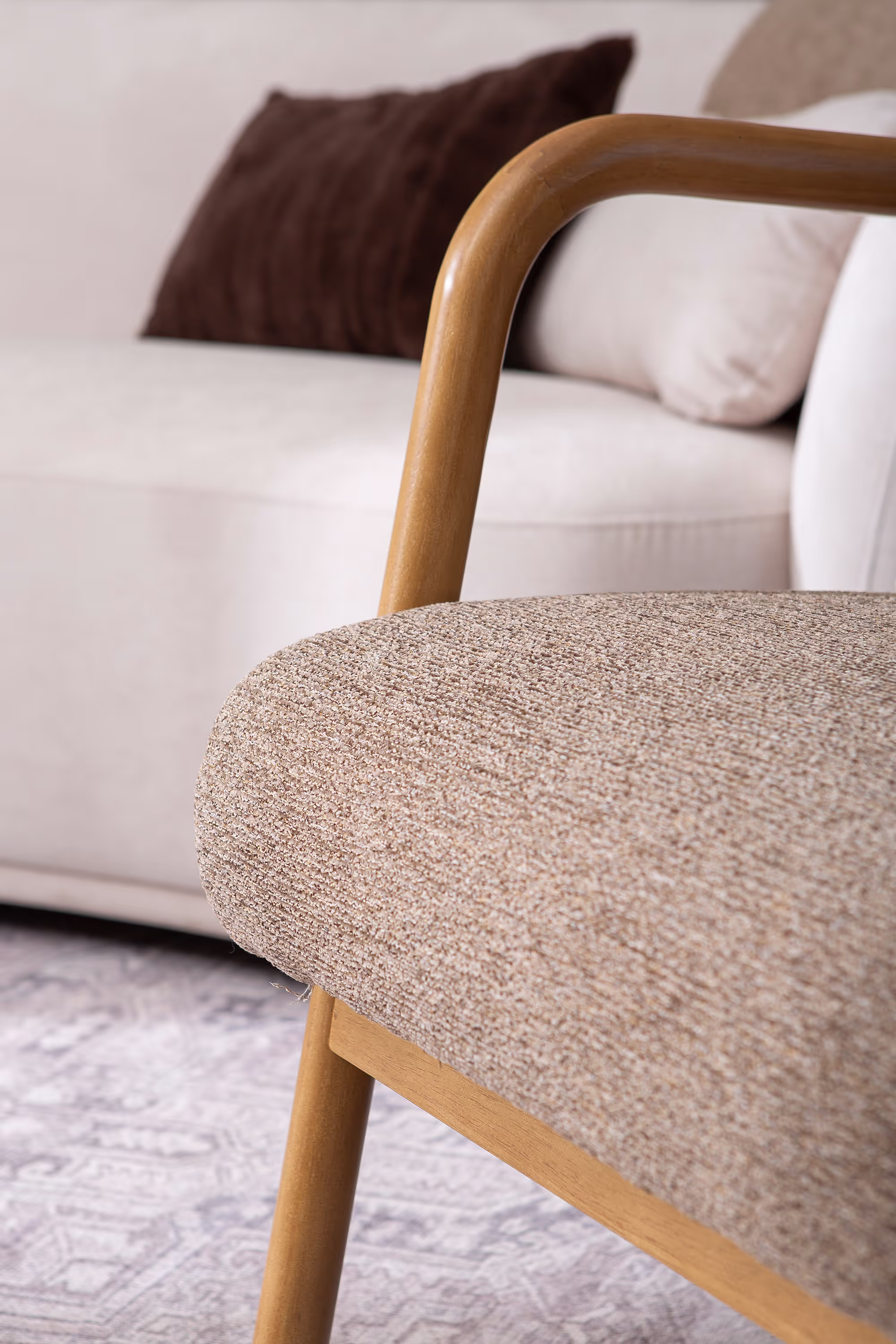 Dove armchair in natural light emphasizing color harmony between brown fabric and wood frame