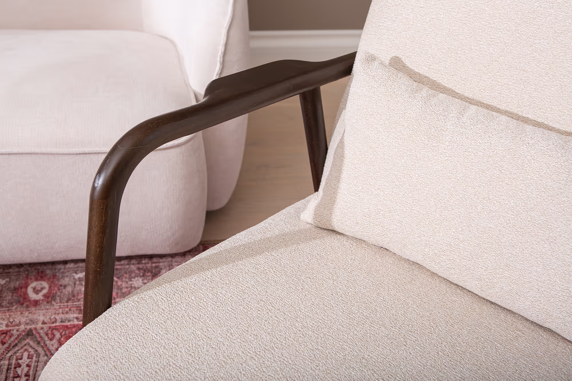 Side profile of Dove armchair showcasing walnut frame and beige fabric seat