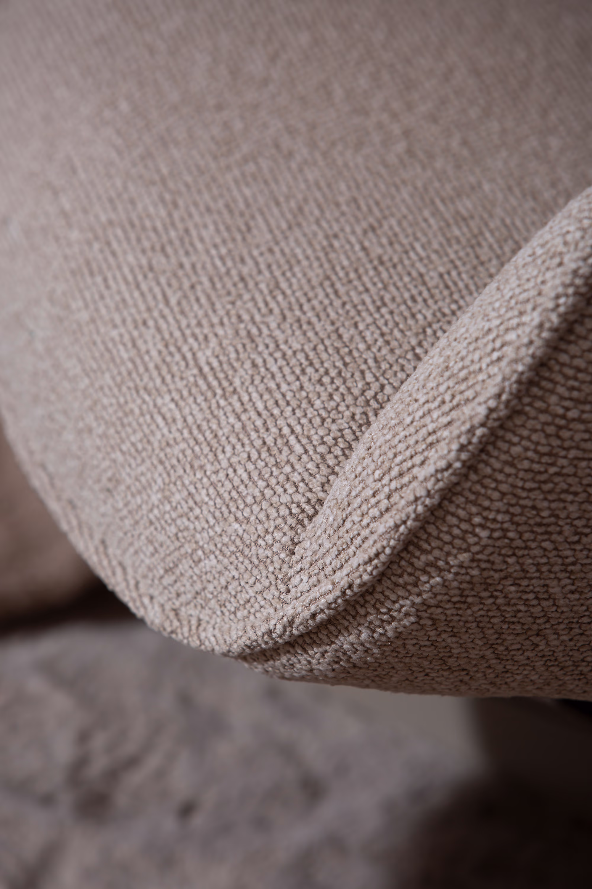 Close-up detail of beige fabric and stitching on Wind TV chair with ottoman