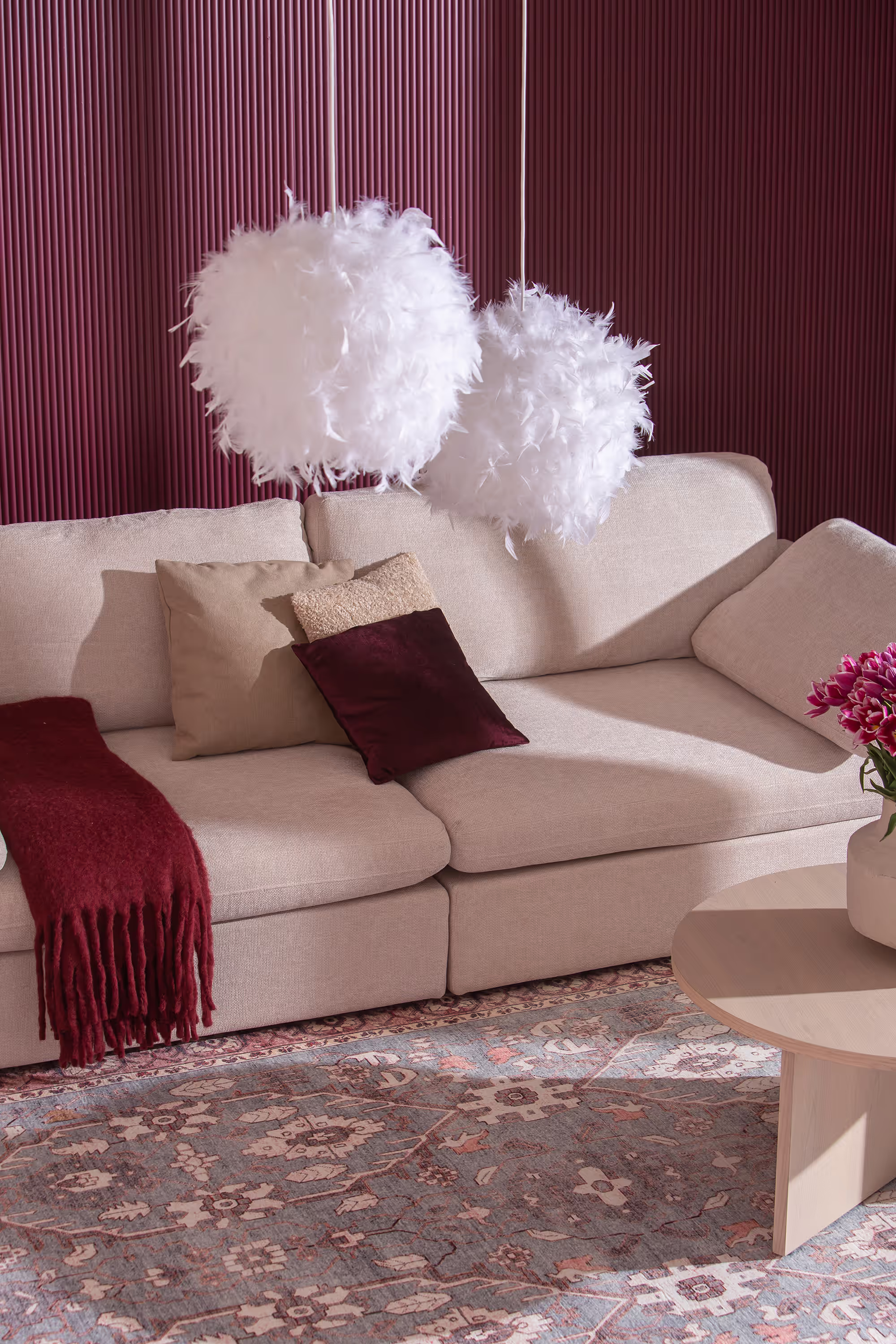 Decorative view of the beige sofa paired with wooden coffee table and carpet styling