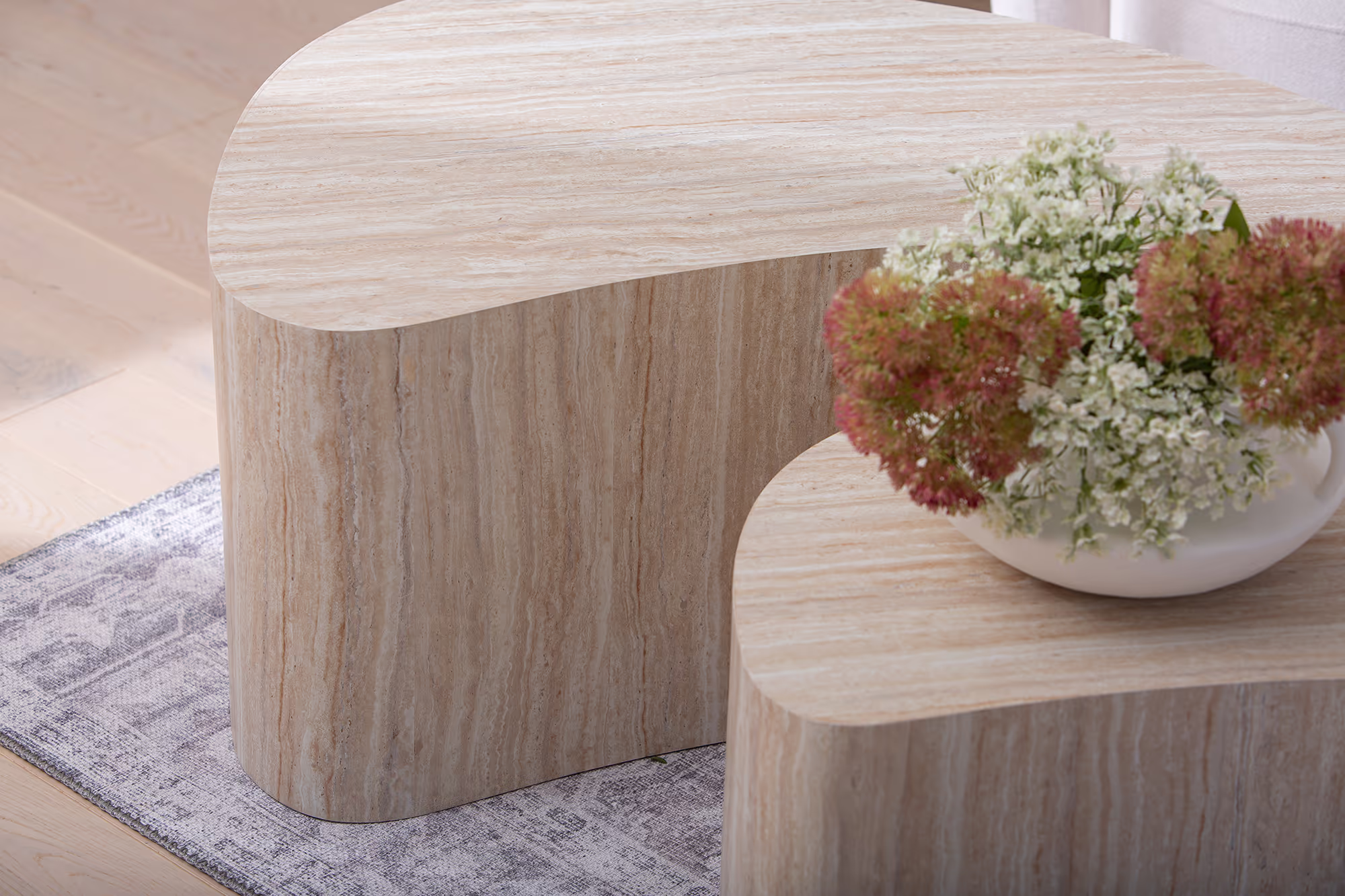 Detail of the beige finish reflecting soft natural light on the Island tables' surface.