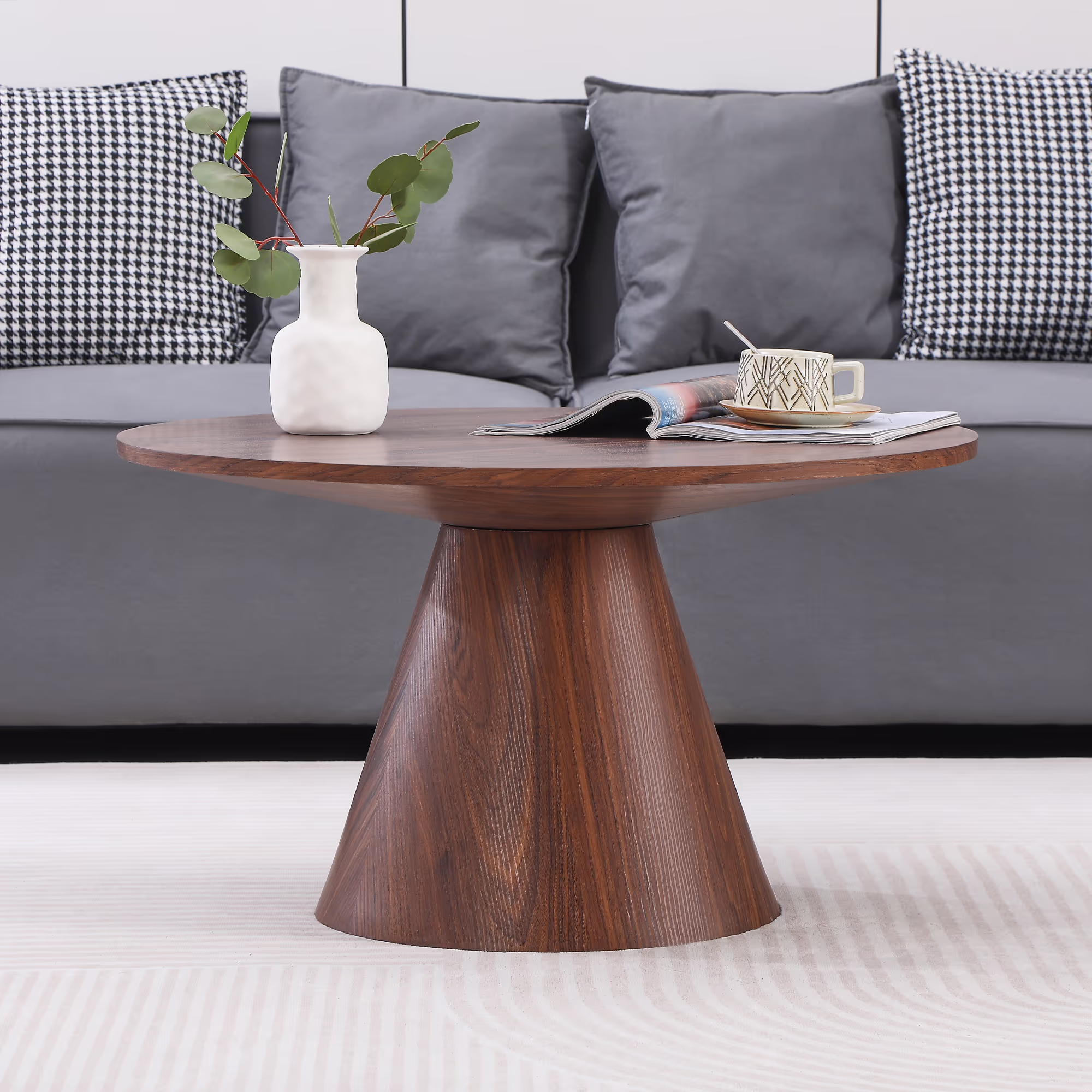 Side view of the Islet coffee table highlighting its round tabletop and mid-century modern style walnut legs.