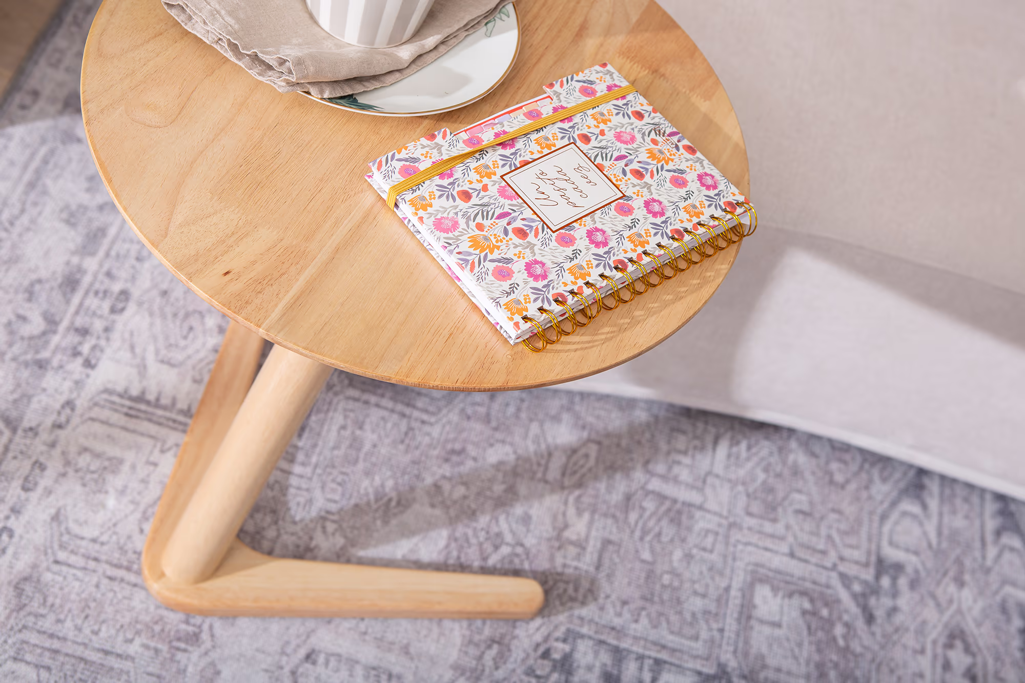 Detail shot of the Swallow side table's smooth wooden tabletop surface in natural finish