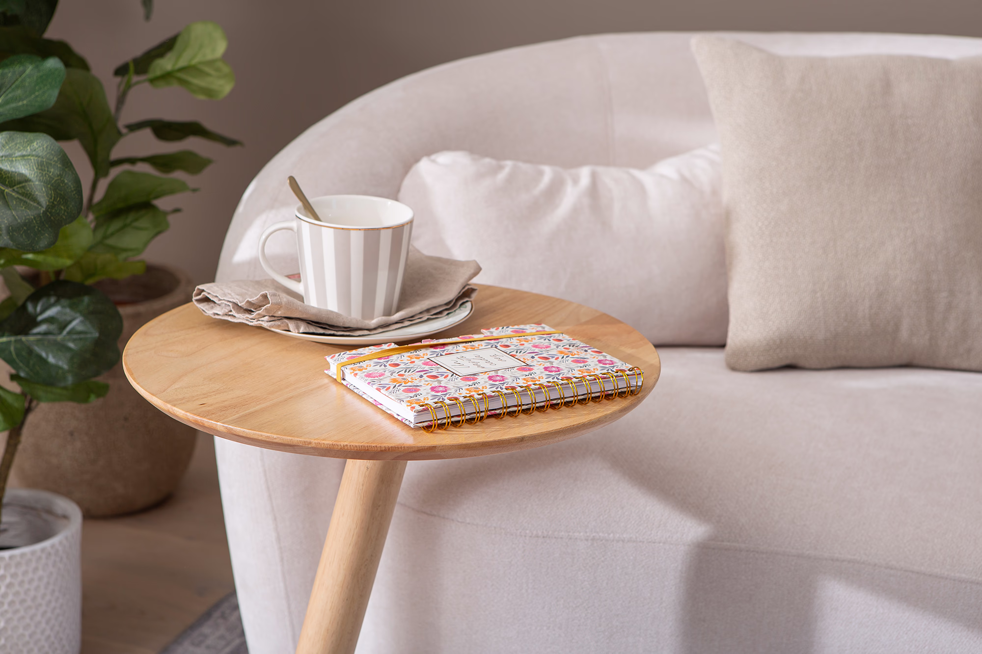 Side view of Swallow round side table showing elegant tapered legs and round tabletop
