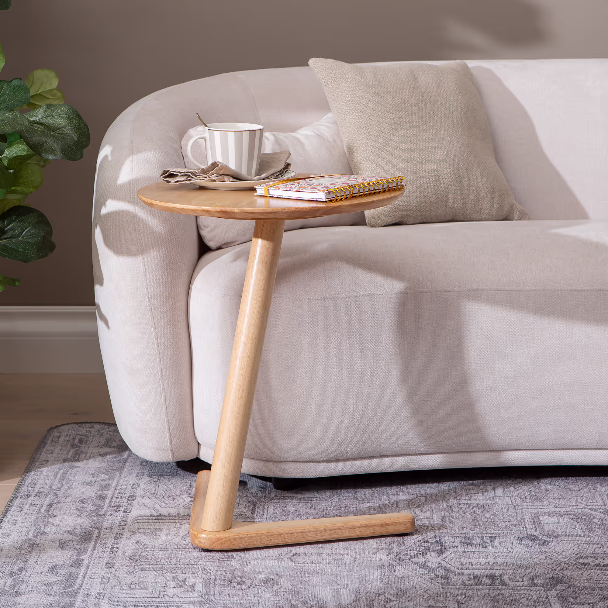 Swallow side table placed in a modern living room setting with décor accents